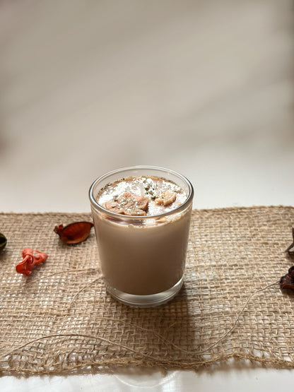 Bougie marrons anti stress au senteur de noisette avec des petites feuilles au dessus et des paillettes